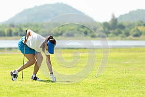 Golfer sport course golf ball fairway.Â  People lifestyle woman playing and putting golf ball game on the green grass.